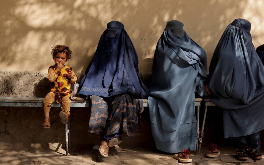 A girl sits with women wearing burqas outside a hospital in Kabul, Afghanistan October 5, 2021. REUTERS/Jorge Silva     TPX IMAGES OF THE DAY